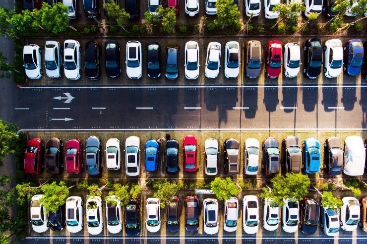 Large car park with no spaces left and lots of trees