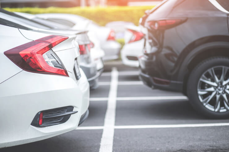 Rear view of the back of cars, white car on the left and black car on the right