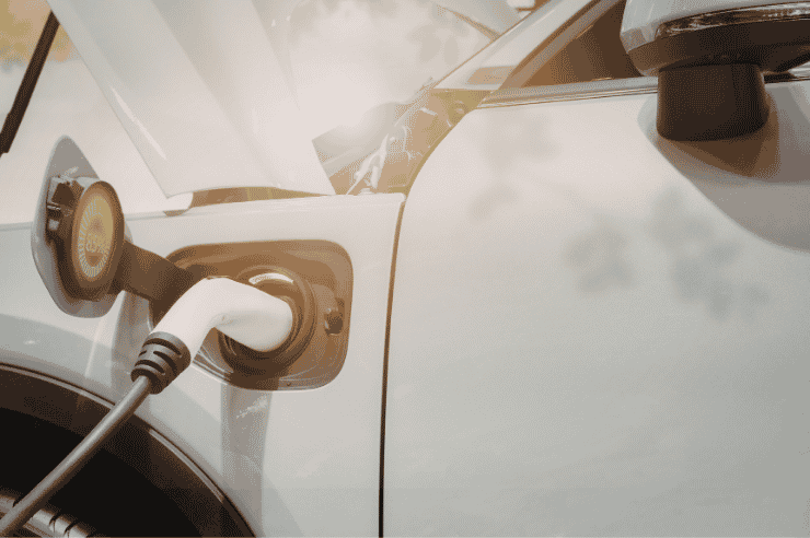 White electric jeep in the sun plugged in and charging
