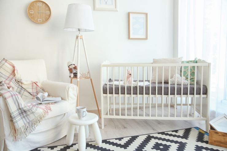 Cot Light coloured nursery with cot and large corner chair
