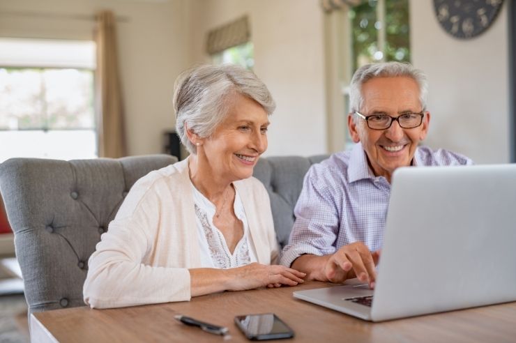 Elderly couple sitting in front of a laptop