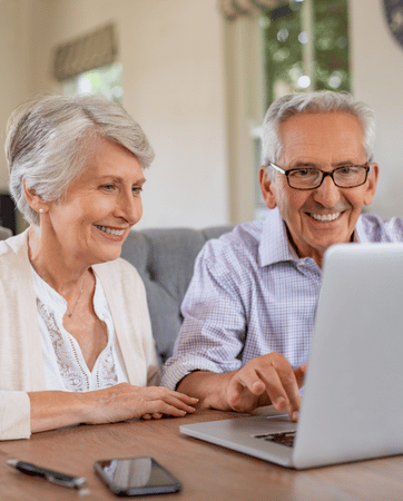 Couple sitting at the table looking in at a laptop