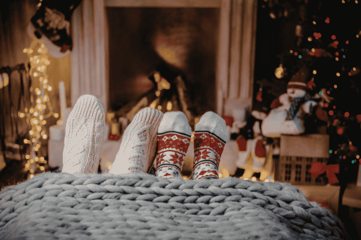 Cozy Textures Two people resting on a sofa, their feet stick out of the bottom of their blanket