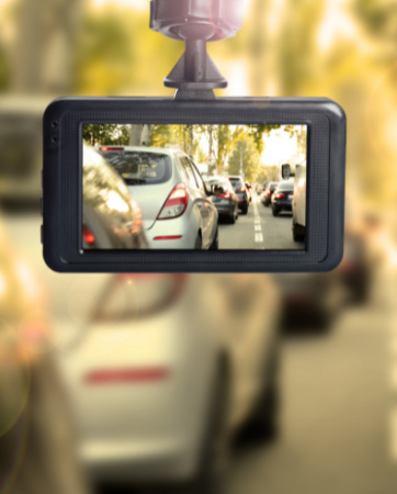 Photo of dashcam showing cars driving ahead with a blurred background