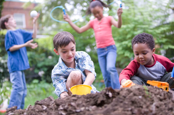Children playing in the mud in the garden Four children playing with mud, a ball and skipping rope