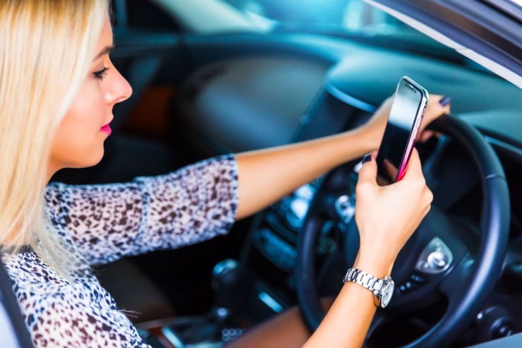 Young woman driving on phone | Car insurance Ireland | An Post Insurance