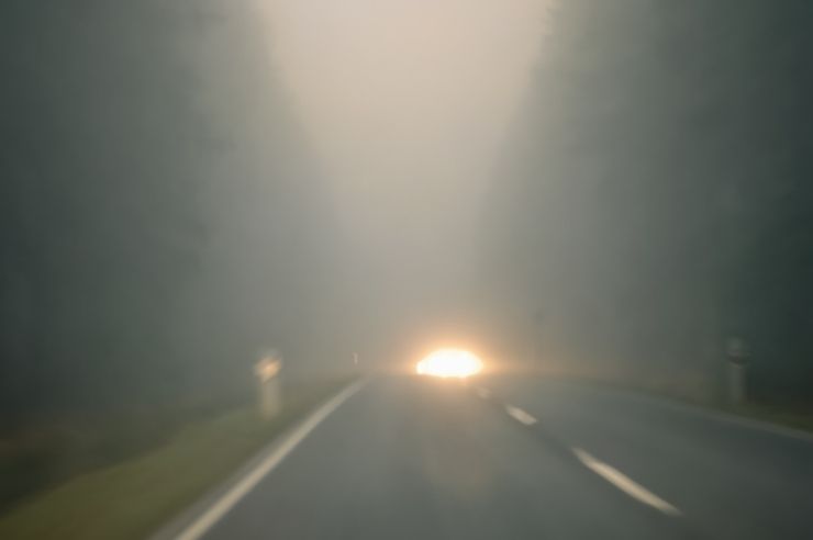 Foggy road conditions Inside view of vehicle driving on dark, foggy road