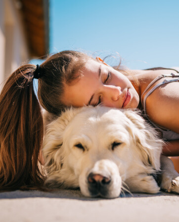 Girl hugging a sleeping golden retriever