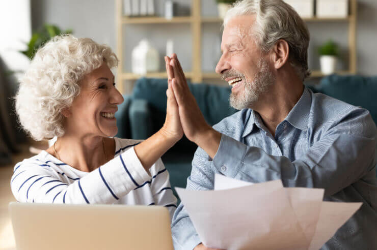 High Five Happy retired couple after planning their will | Funeral Insurance Quotes