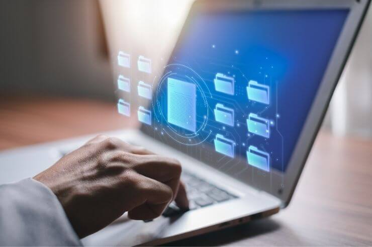 Person managing documents digitally on laptop
