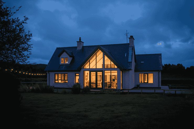External view of home with large windows and internal lights lit