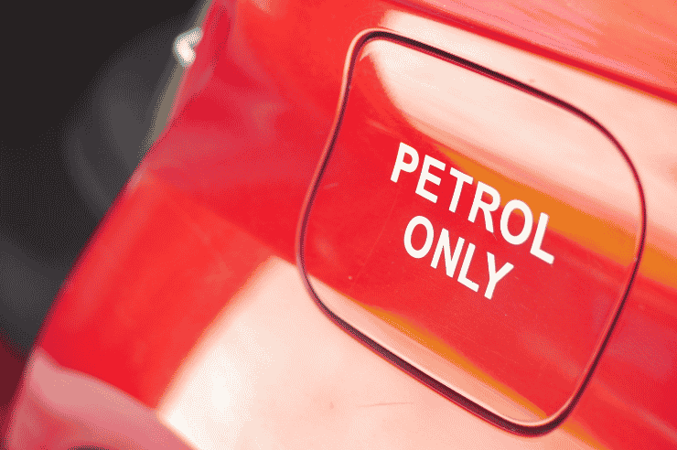 Close-up shot of a fuel cover on a red car with the label 'petrol only'