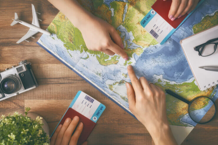 A map pictured on a table with two hands pointing to a specific location