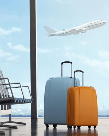 two suitcases in the airport beside chairs with an aeroplane flying in the background