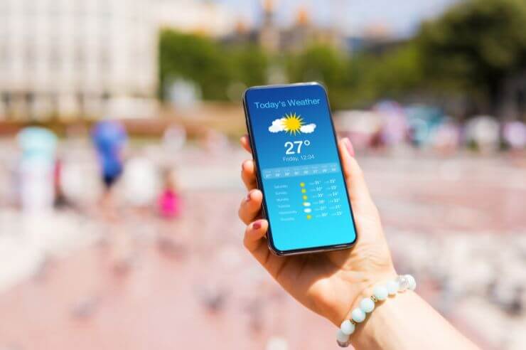 Weather Apps Hand holding smartphone showing daily weather forecast