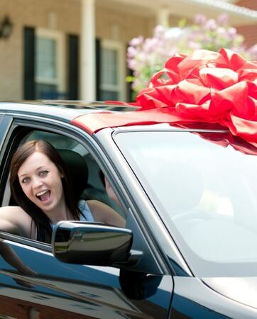 Young girl head out window celebrating after buying her first car