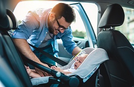 Dad putting baby in car