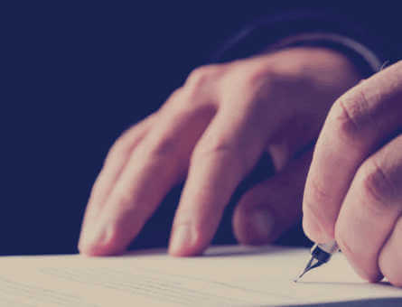 Close-up of a person signing an important document with a pen, symbolising policy agreement and cover activation.