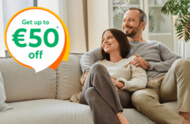 Couple relaxing together on a sofa at home with text overlay “Get up to €50 off”, promoting home insurance savings in Ireland.